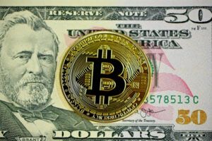 a bitcoin and 50 dollars note